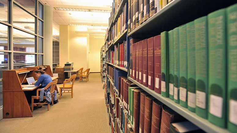 A student studying by the bookstacks in Schaffer Library
