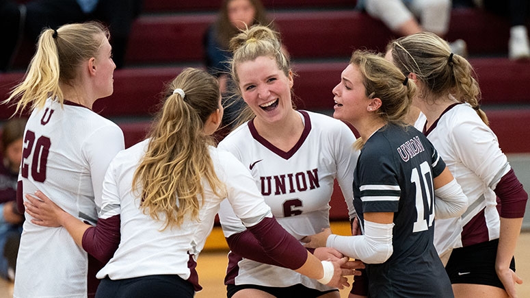 Members of the women's volleyball team jubilantly cheer and congratulate each other following a victorious game