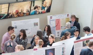 In the Wold Atrium Students review posters describing their research projects