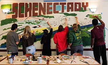 Photo by Ezra Gollan '26 - Students painting a mural in West dining hall