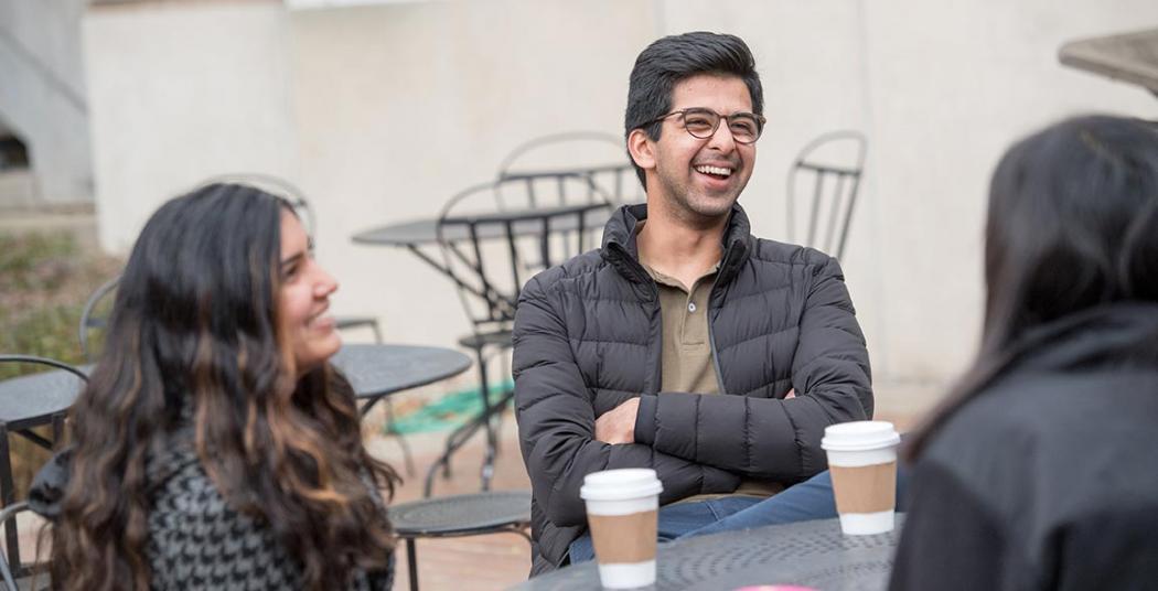 Students enjoying a causal conversation and coffee outside Reamer Campus Center.