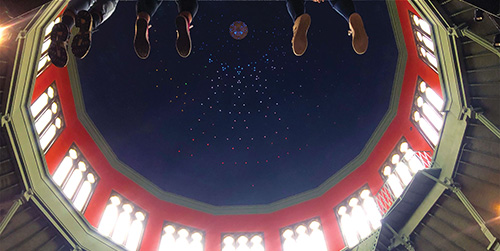 Students sitting in the Nott with feet dangling off the side of the second floor.