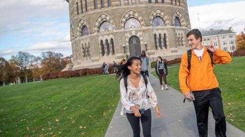 Students walking across campus with the Nott Memorial in the background