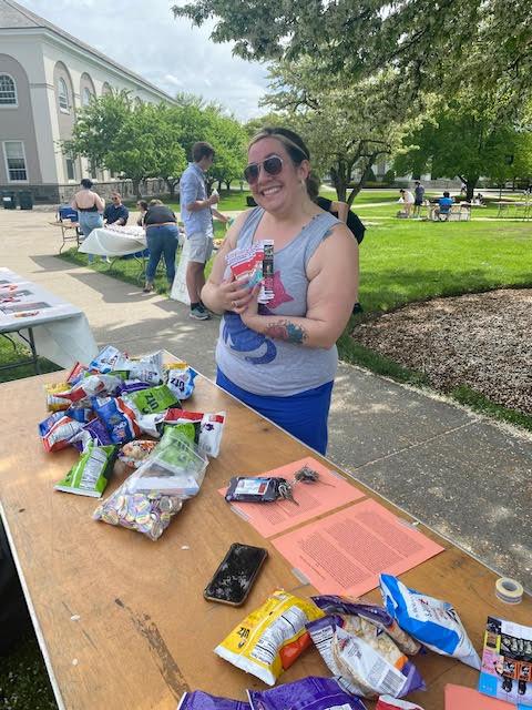 Dr. Jen Mitchell, Associate Professor of English at Union College, stands at a Pride Fest table.