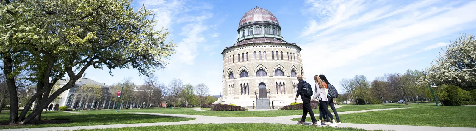 Students walking across campus with the Nott Memorial visible in the background.