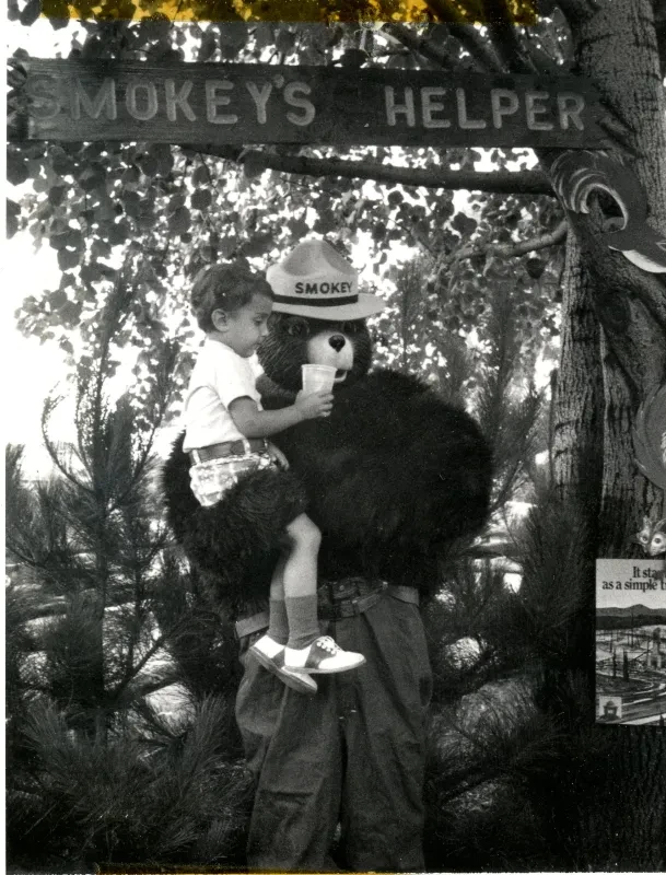 Smokey the bear posing with a child