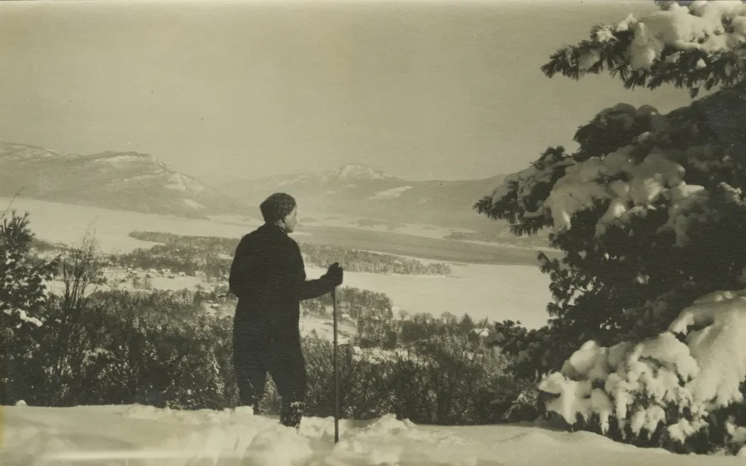 Photo of a man on skis on a mountain overlooking a lake