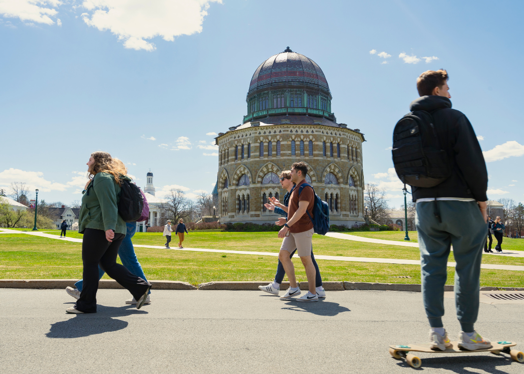 Students walking on campus with Nott Memorial in background.