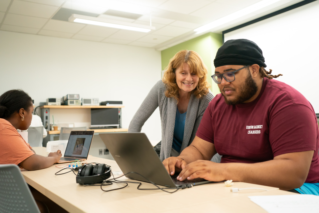 Faculty member working closely with student in a lab.