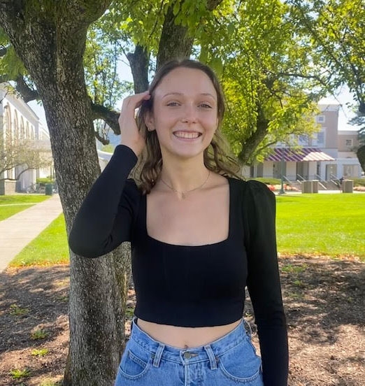Marcy Forti, class of 2022, standing in front of a tree.