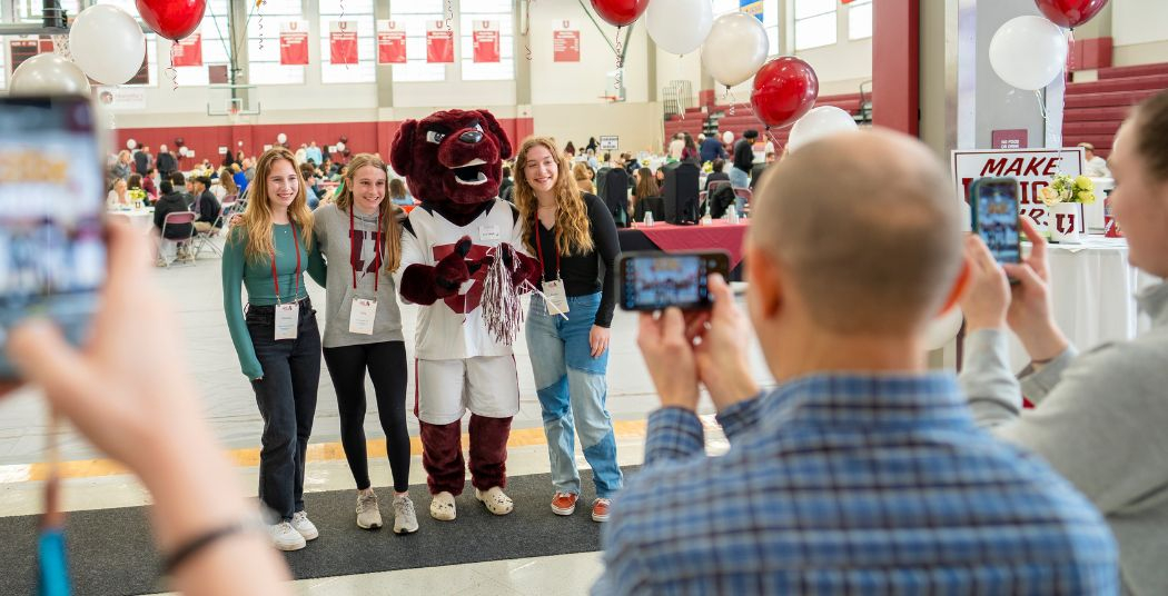 Admitted students taking a photo with Charger mascot during an admitted student day.