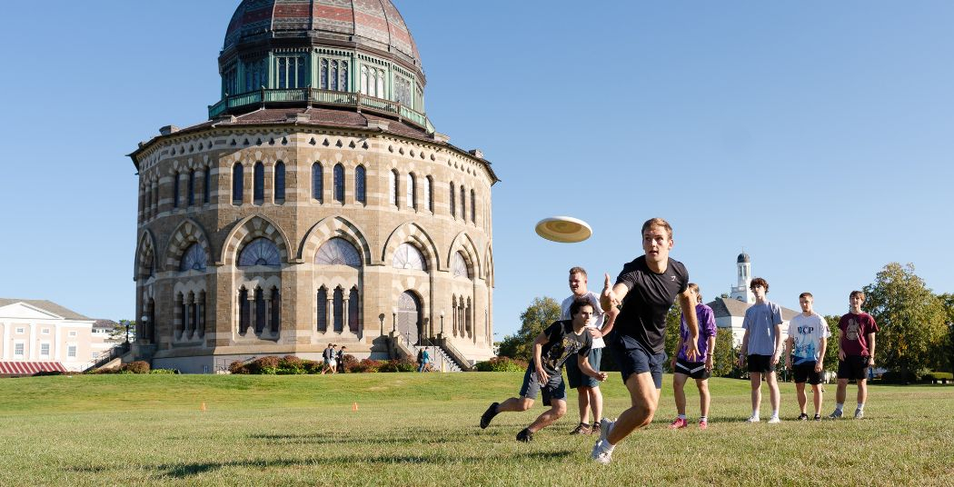 Students playing ultimate frisbee in front of the Nott. 