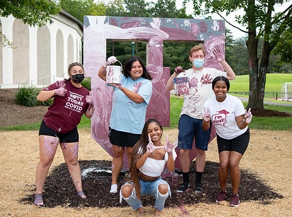 Student painters pose in front of the new Block U sculpture