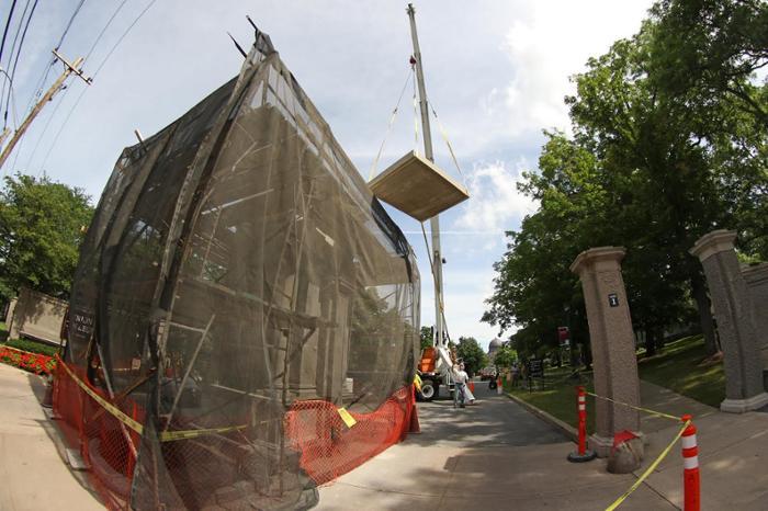 Workers prepare to reset the nearly three-ton cap of the monument.