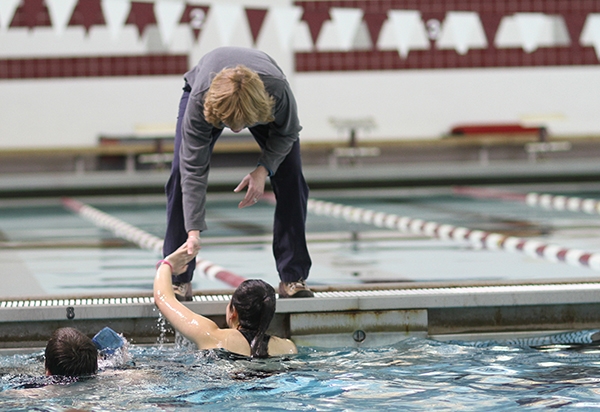 Trainer Cheryl Rockwood high fives a student in the pool.