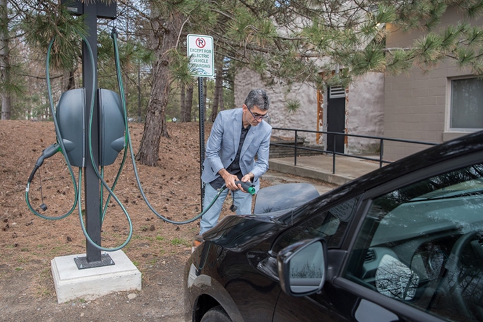 Daniel Mosquera charges his electric vehicle on campus on a recent morning.