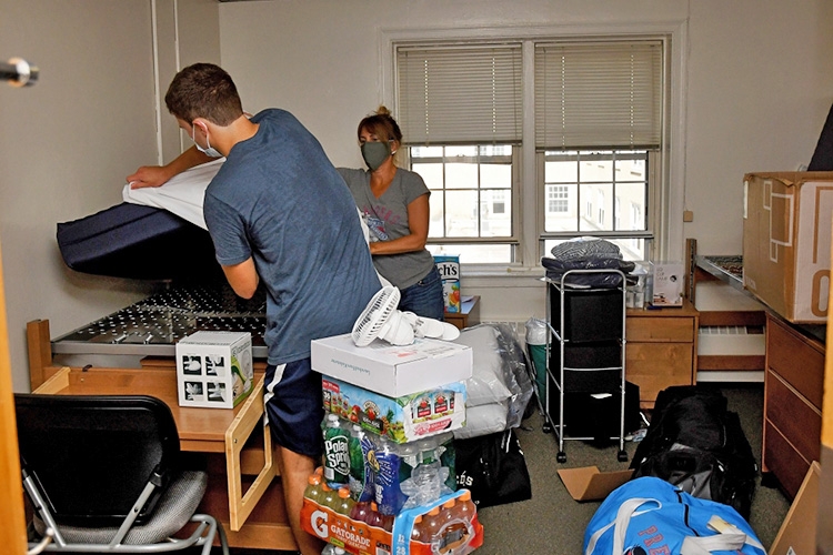 A student moving into a dorm room on campus