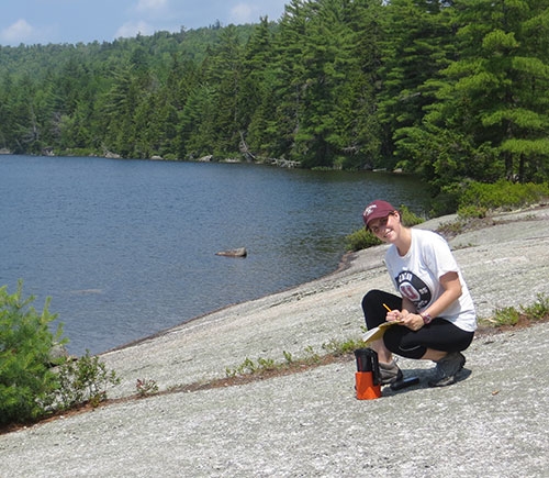Olivia Thurston '16 measures the radioactivity of granite at Partridge Pond in Amherst, Me.
