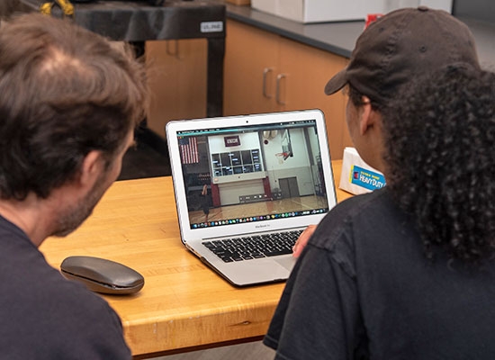 Working in the physics lab, Professor Marr and Santana ’21 analyze the data to determine the angle and velocity of the student's shots.