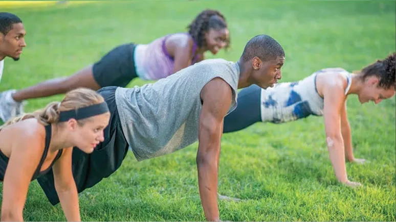 People doing push-ups on the lawn