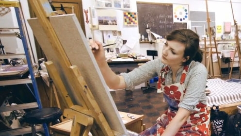 Student Jasmine Roth painting a canvas.