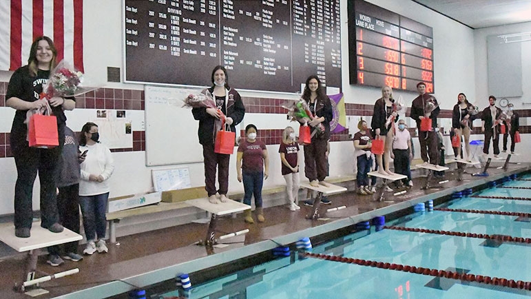 Members of the women's swimming and diving team are presented with bouquets.