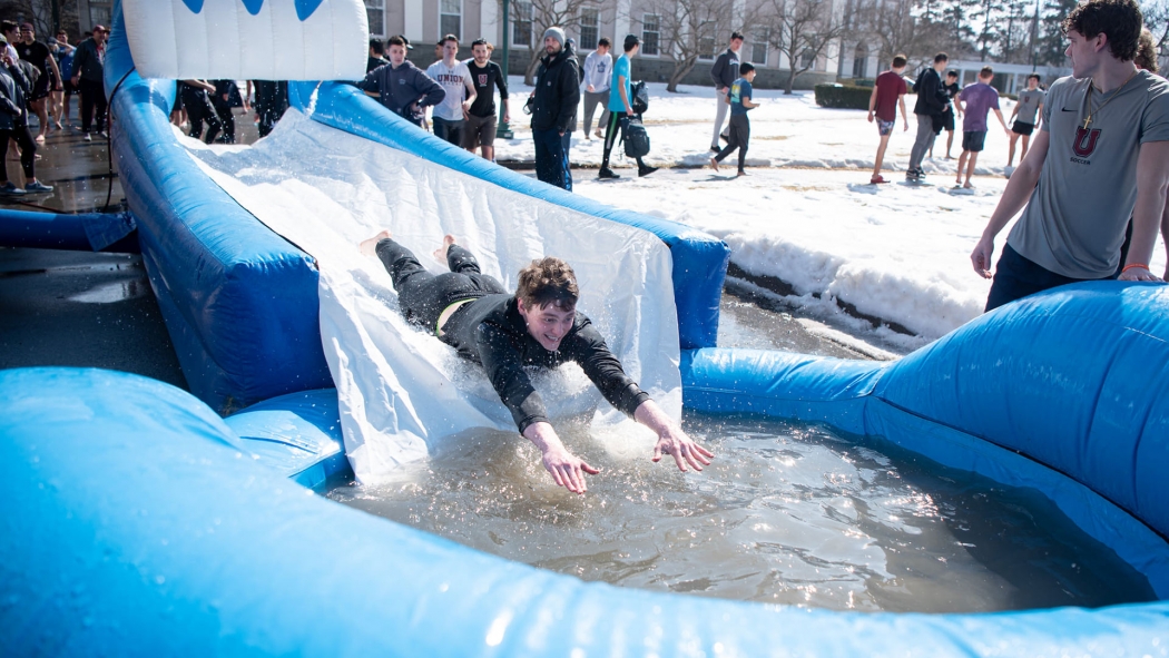 A student sliding into an icy poool of water