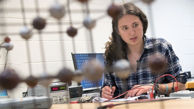 A student making some calculations in a physics class