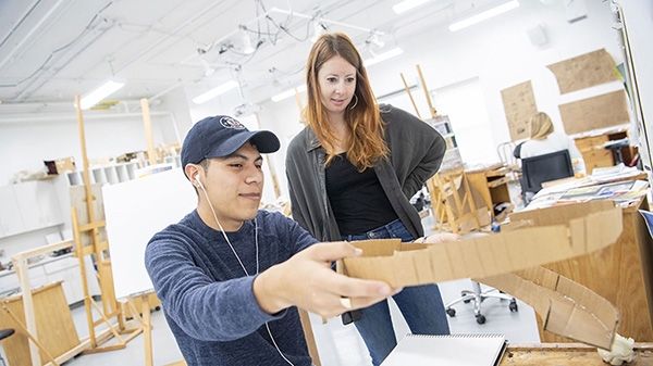 A student shows his art project to Laini Nemett, the John D MacArthur Associate Professor of Visual Arts 