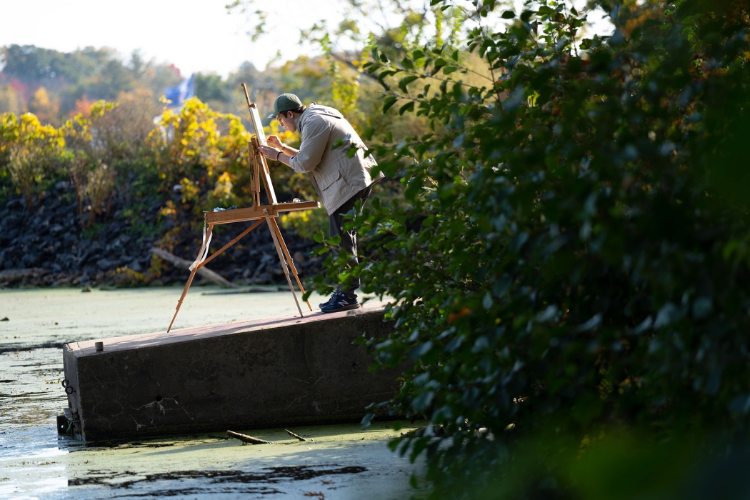 A student paints outdoors 