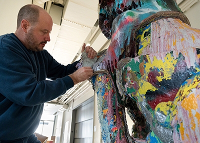 Scott Cober, associate conservator at the Williamstown Art Conservation Center, removes layers of paint from the Chinese stone lion on Dec. 1, 2022
