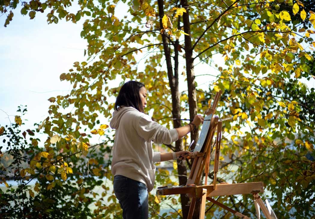 A student paints outdoors 