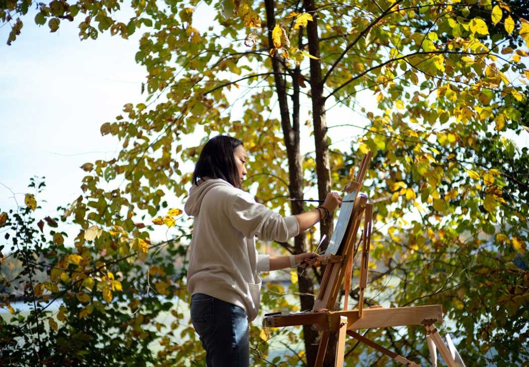 A student paints outdoors