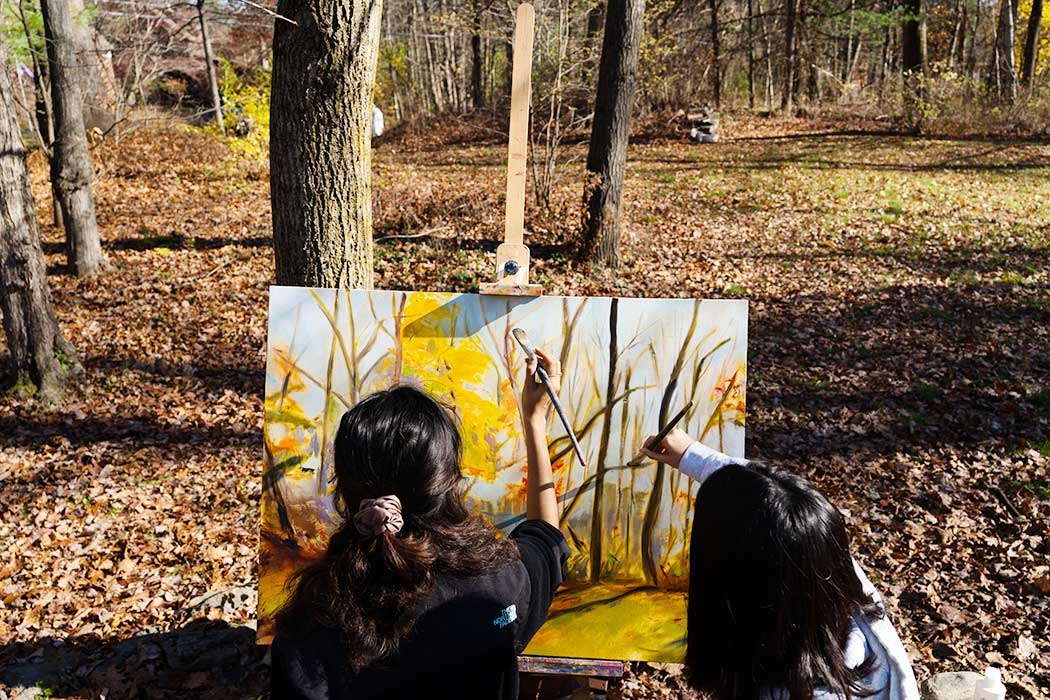 Students at an easel painting.