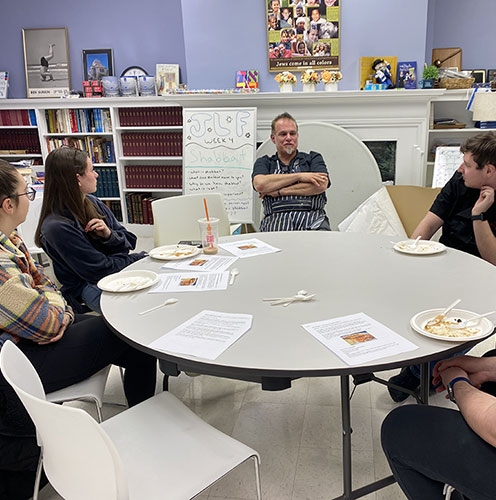 Ric Orlando, center, enjoomg latkes and conversation with some Hillel students