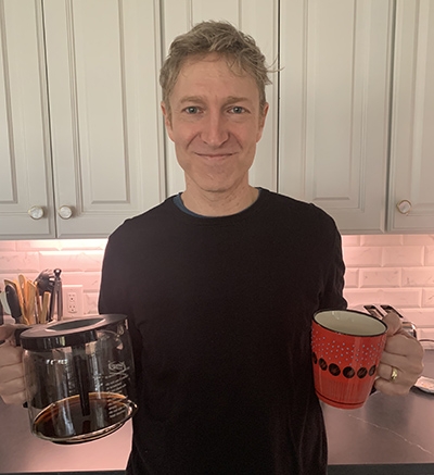 Robert Samet in kitchen with coffee mug and coffe pot in his hands.