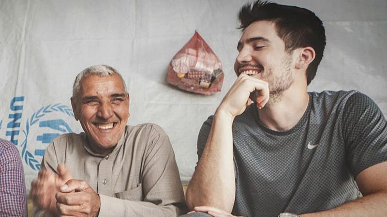 Mike Clarke '11 (right) speaking with an older person,