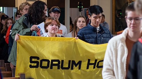 Students holding a Sorum House banner as they process through Memorial Chapel.