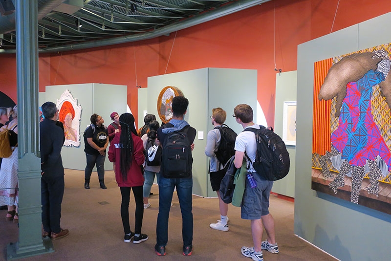 Students looking at art on display in the Wickoff Student Gallery