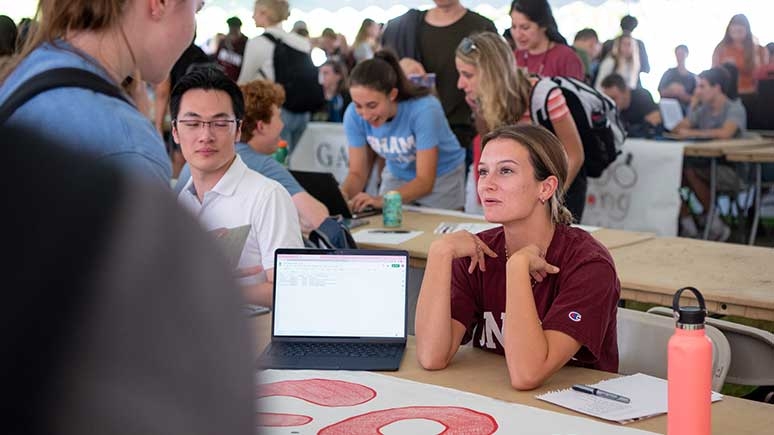 A student staffing a booth at Club Expo, representing on of the many clubs students may join while at Union.