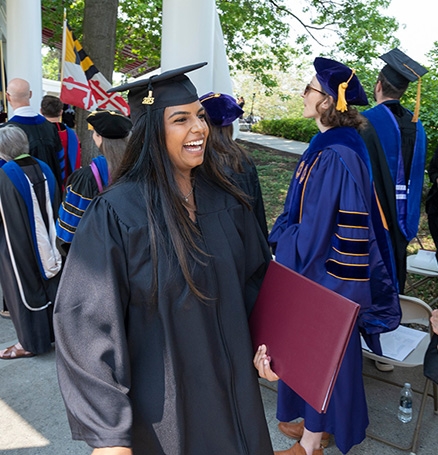 A student smiling after receiving her diploma at  2023 Commencement exercises.