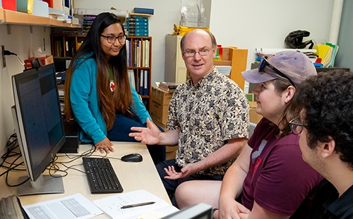 Professor Francis Wilkin discusses the interpretation of an exoplanet light curve with Niha Das '26, left, Will Grimwood '24 and Dimitris Vasileios Zora '26, right.