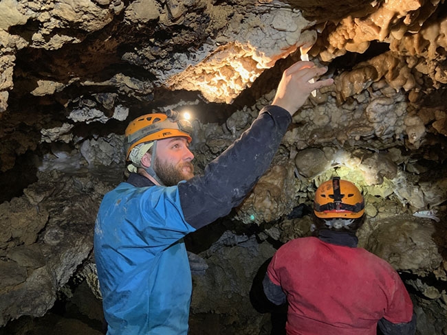 Xander Forsyth '25 collects water samples from a cave in Peru.