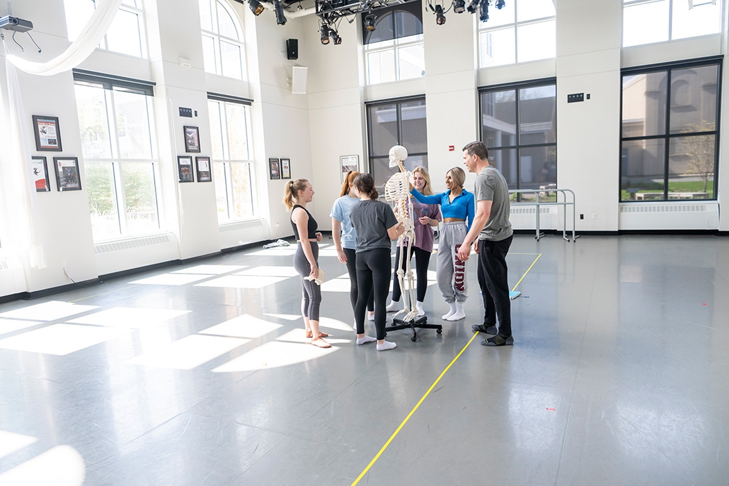 Students in a movement class in Henle examining a skeleton model.