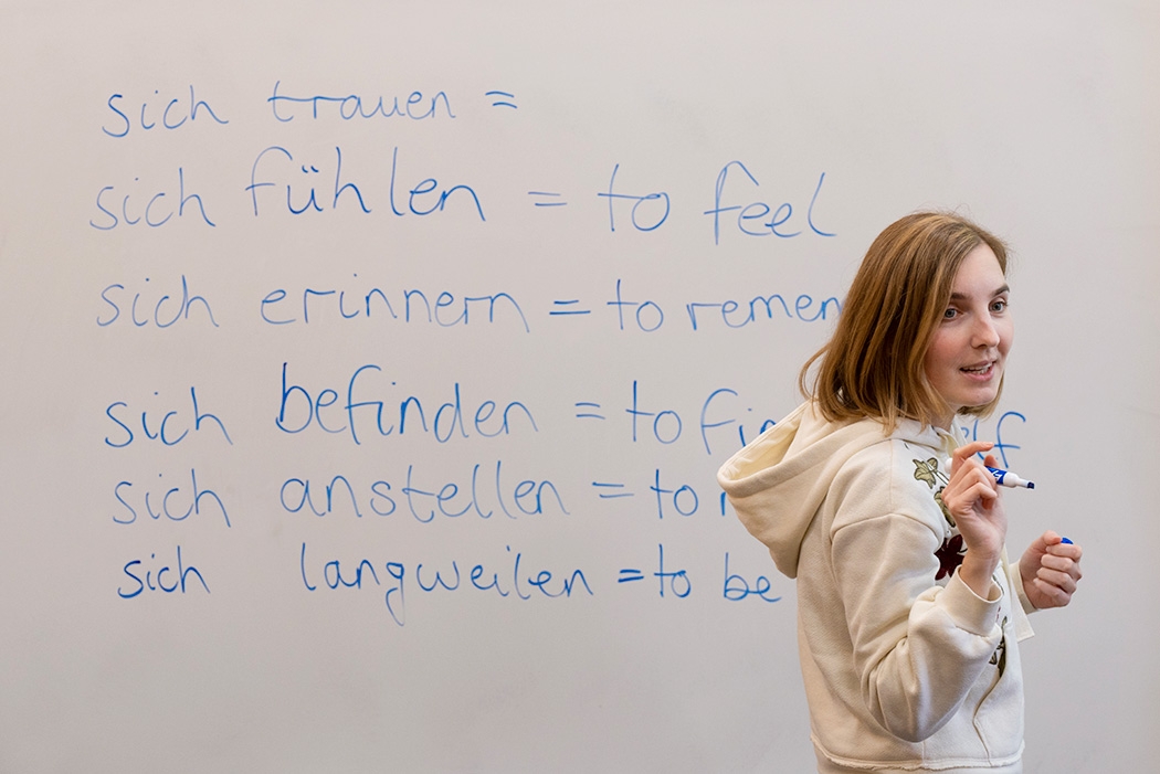 A student writing on a whiteboard in the Language Center.