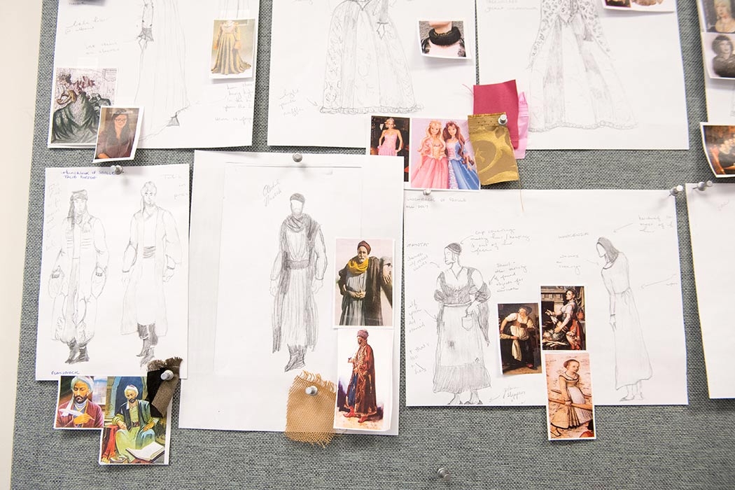 A close=up of some sketches and illustrations of costume being crafted in the costume shop. 