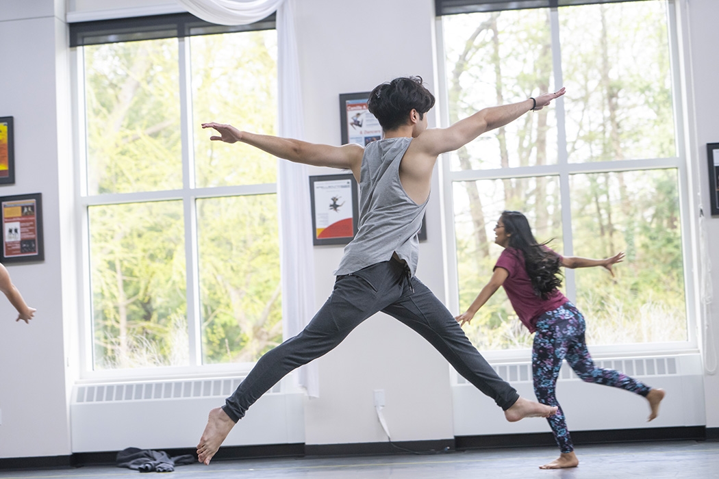 A student leaping as part of a dance routine performed in Henle Pavilion.