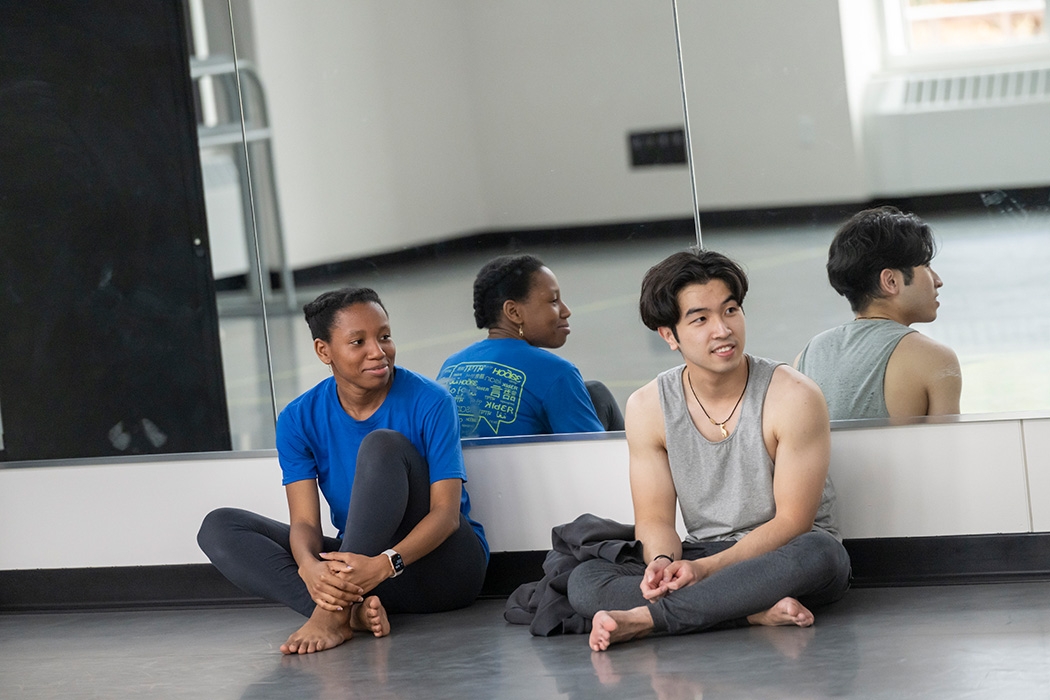 Students seated on the pavilion floor during a dance class break.