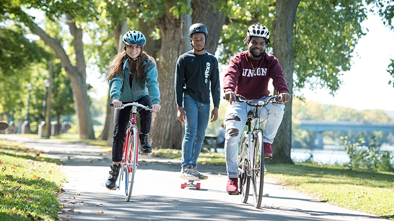 Students biking and skateboarding on one of the local bike paths.