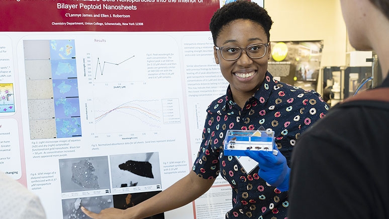 A student points to a poster during a presentation at the Steinmetz Symposium.